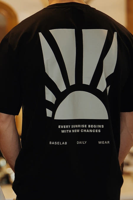 T-shirt noir à manches courtes de BASELAB, avec une impression graphique d'un soleil levant sur le dos.
