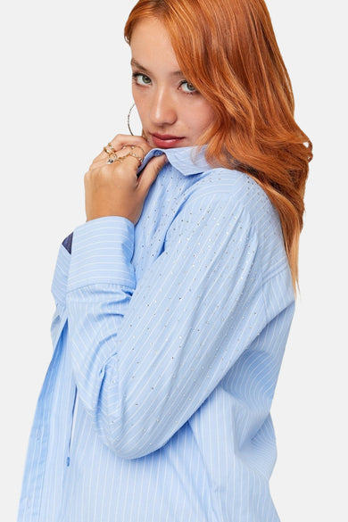 Blau,, rayé chemisier à manches longues de TALLY WEIJL, orné de taches argentées et porté avec des bagues d'or et des boucles d'oreilles.