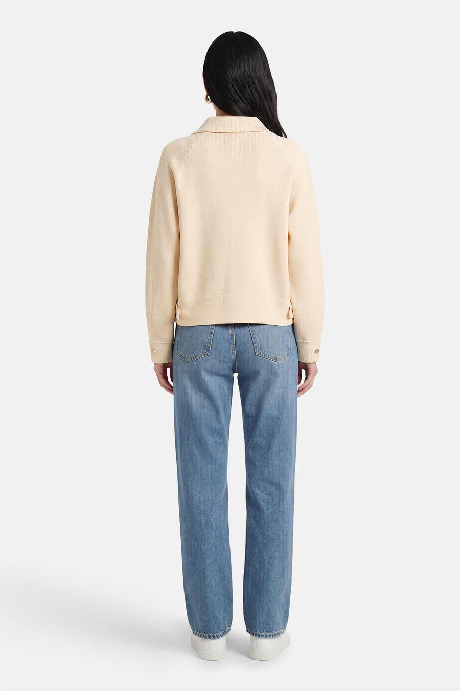 Gilet écru d'ADORE, vu de dos, combiné avec un jean et des chaussures blanches.