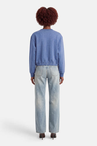 Pull bleu ADORE, à manches longues et combiné avec un jean et des talons.