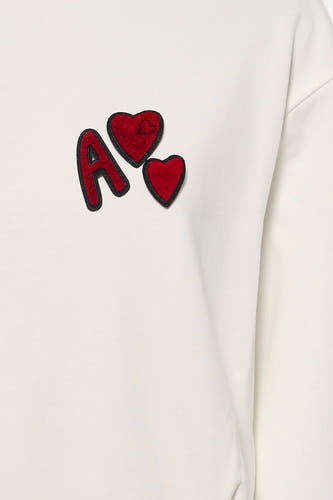 Sweat-shirt blanc ADORE avec lettre "A" rouge et applications en forme de cœur.