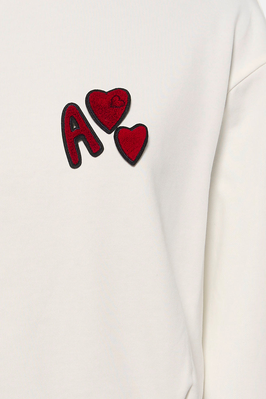 Sweat-shirt blanc ADORE avec lettre "A" rouge et applications en forme de cœur.