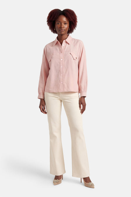 Roze hemd van ADORE, met lange mouwen, knoopsluiting en borstzakken. Gedragen met crèmekleurige broek en versierde pumps.