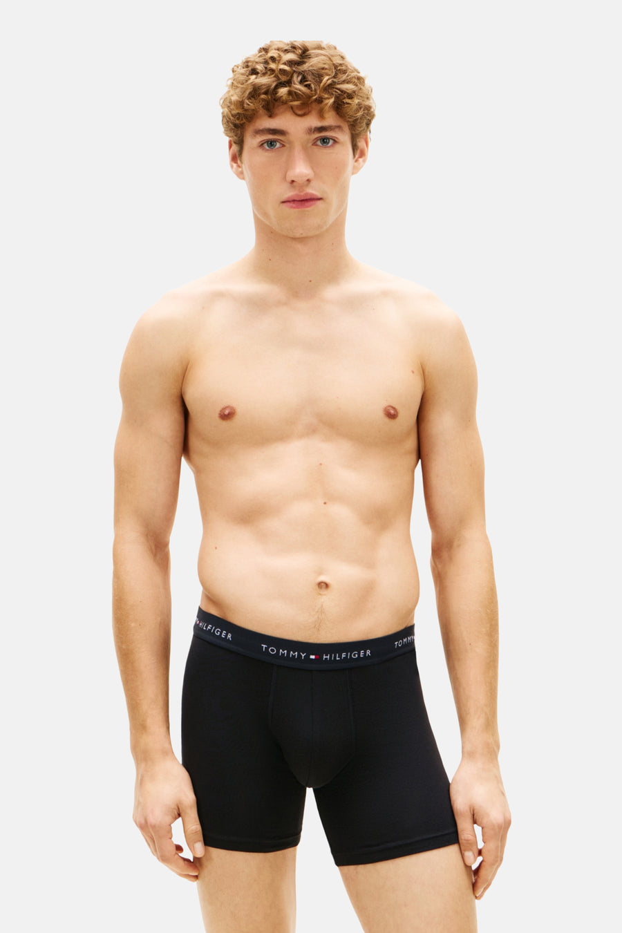 Man, ontbloot bovenlijf, zwarte Tommy Hilfiger boxershort.
