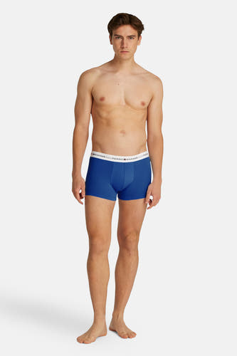 Boxer short en coton bleu de TOMMY JEANS, porté par un modèle masculin avec le haut du corps nu.