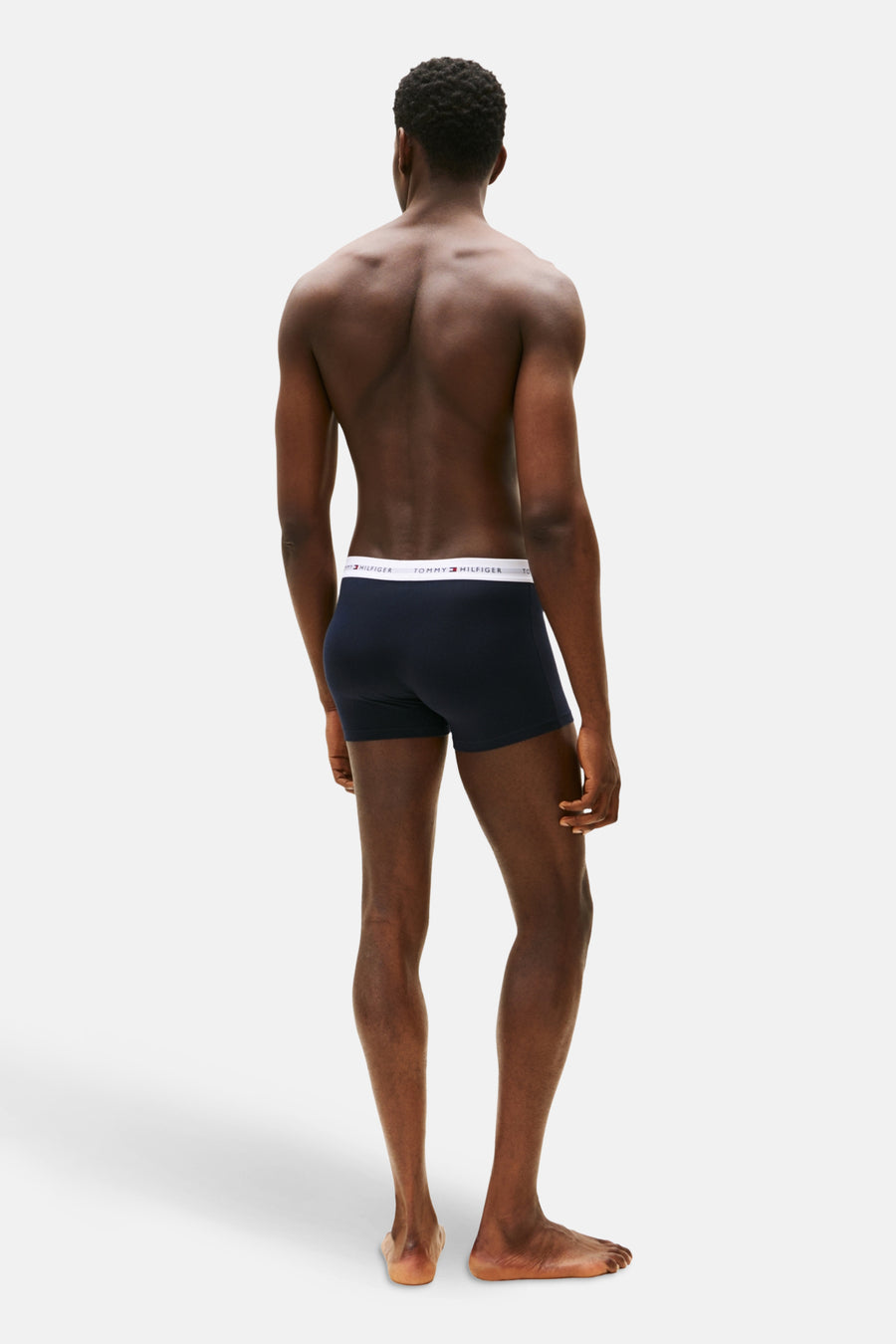 Man in blauwe Tommy Hilfiger-boxers, achterkant.
