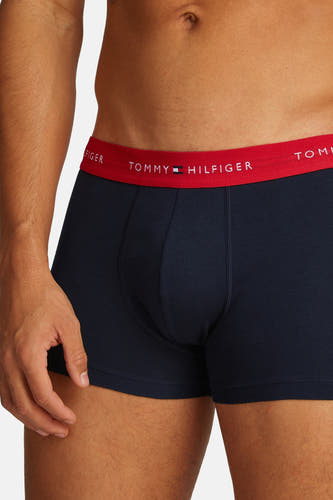 Boxer short bleu de TOMMY JEANS, avec une bande rouge à logo, gros plan.