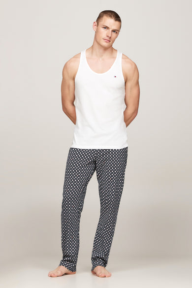 Sous-vêtement blanc de TOMMY JEANS, porté avec un pantalon de pyjama à motif géométrique.