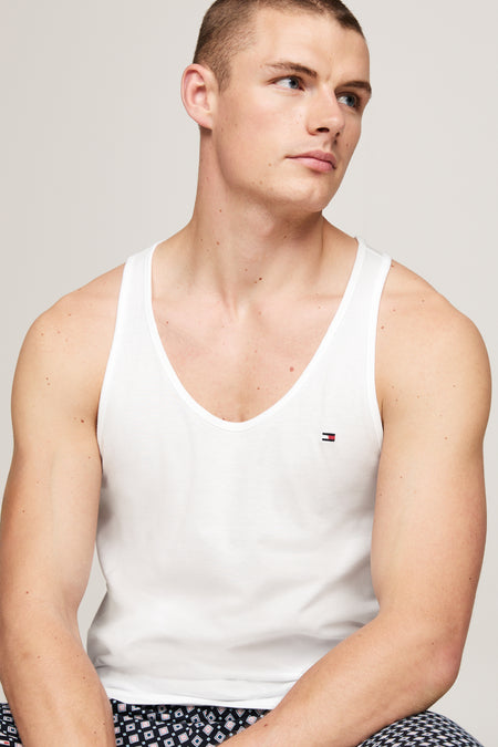 Sous-vêtement blanc de TOMMY JEANS, porté avec un pantalon de pyjama à motif géométrique.