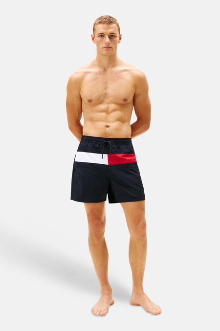 Short de bain bleu de Tommy Jeans, avec un panneau blanc et rouge sur le dessus.