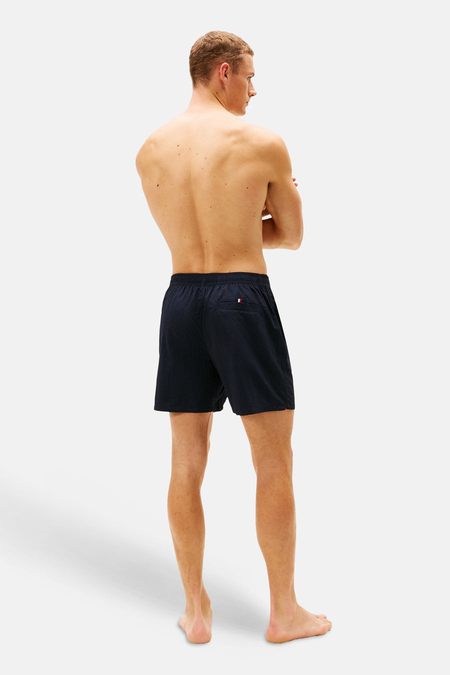 Short de bain bleu de TOMMY JEANS, vu de dos, avec un petit drapeau logo sur la poche arrière.