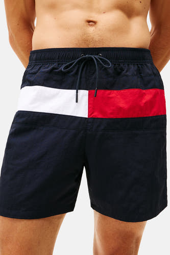 Short de bain bleu Tommy Jeans avec une bande horizontale rouge et blanche.