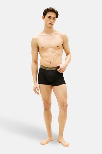 Boxer noir de TOMMY JEANS, porté par un homme torse nu.