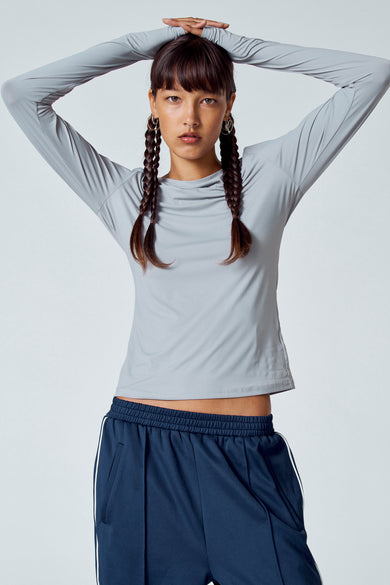 T-shirt gris à manches longues d'Unwind, vu de dos, associé à un pantalon bleu marine.