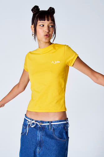 Geel T-shirt met korte mouwen van Unwind, gedragen met laaghangende jeans en een koord als riem.