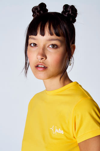 T-shirt jaune à manches courtes de Unwind, porté par une femme aux cheveux relevés.