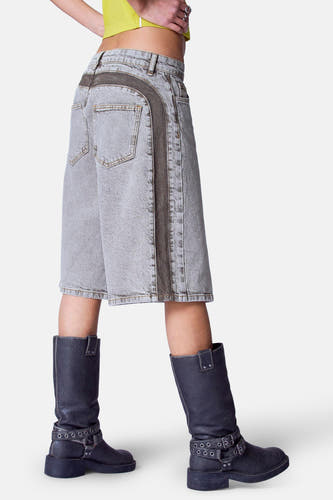 Korte mid grey denim broek van Unwind, met donkere zijstrepen en zwarte leren laarzen.
