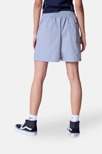 Short gris Unwind, vu de l'arrièreé combiné avec des chaussettes blanches et des baskets noires à semelles hautes.