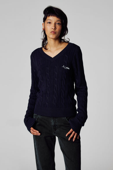 Pull à col V bleu d'Unwind, avec un motif côtelé et un petit logo sur la poitrine.