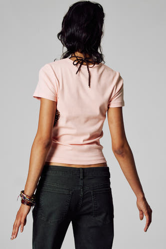 T-shirt rose à manches courtes d'Unwind, avec un détail de côtes à l'arrière, associé à un pantalon corduroy foncé et des bracelets.