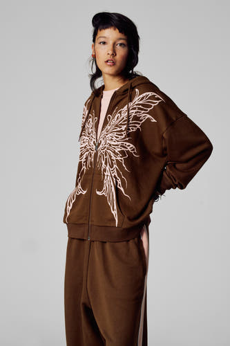 Veste brune d'Unwind, avec un grand motif de papillon rose et une pantalon brune correspondant.