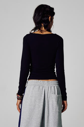 T-shirt noir à manches longues d'Unwind, vu de dos, associé à un pantalon de jogging gris.