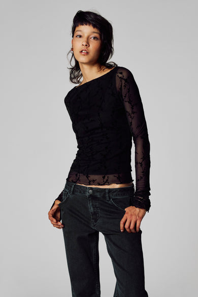 T-shirt noir à manches longues d'Unwind, avec un motif floral et associé à un pantalon en corduroy.