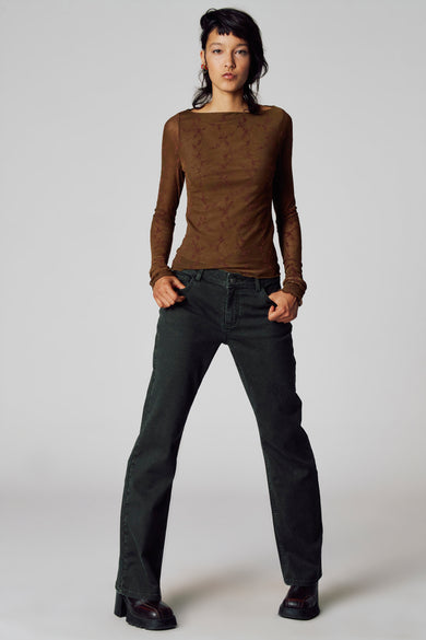T-shirt à manches longues marron Unwind, avec un motif floral, associé à un pantalon foncé et des chaussures sur plateforme.
