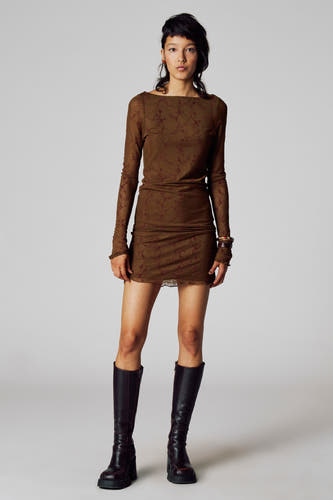 Robe brune à longues manches de Unwind, avec un motif subtil, associée à des bottes noires à talon.