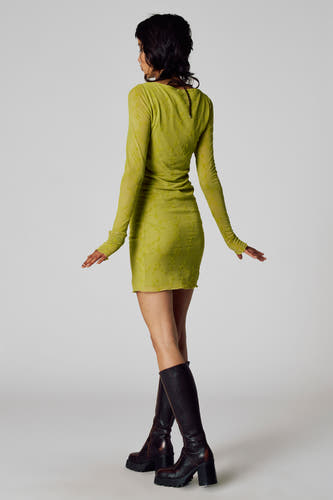 Robe verte à longues manches d'Unwind, avec un motif floral subtil et associée à des bottes hautes.