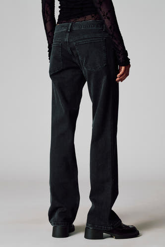 Pantalon gris Unwind, vu de l'rière avec avec une texture corduroy et associé à un haut noir.