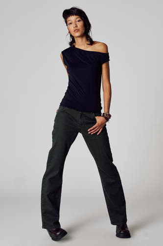 Jeanon de couleur Unwind, avec des jambes larges et porté avec un t-shirt noir et des chaussures marrons.