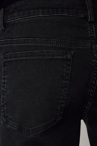 Pantalon de couleur kaki d'Unwind, avec une poche arrière visible et une texture subtile en velours côtelé.