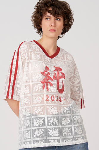 T-shirt blanc à manches courtes d'Unwind, avec des accents rouges et un motif en dentelle.