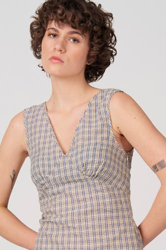 Robe bleue sans manches d'Unwind, avec un motif à carreaux et un col en V.
