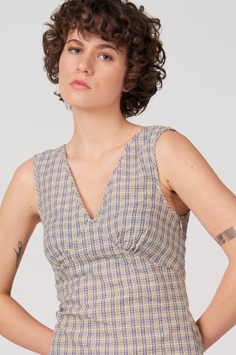 Robe bleue sans manches d'Unwind, avec un motif à carreaux et un col en V.