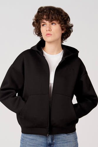 Gilet pull noir d'Unwind, vu de dos, avec capuche et combiné avec un jean bleu.