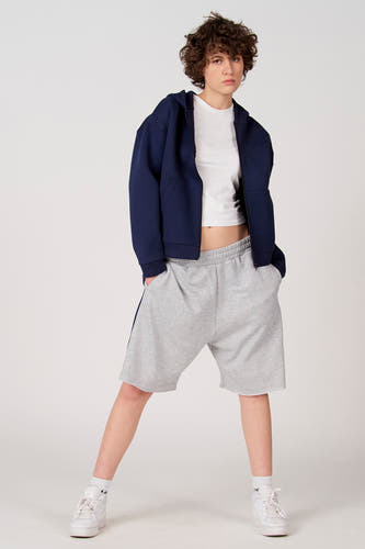 Gilet bleu d'Unwind, combiné avec un T-shirt blanc et un short gris.