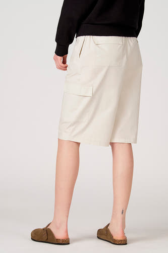 Ecrukleurige short van Unwind met elastische tailleband, zij- en cargozakken, achteraanzicht op model.