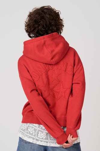 Rode sweater met kap van Unwind, met sterren en letters op de achterkant.