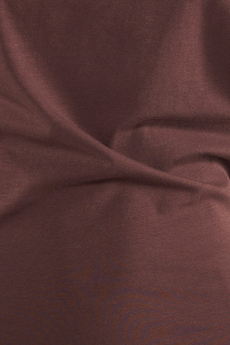 T-shirt marron d'Unwind, avec une texture visible et des plis doux dans le tissu.