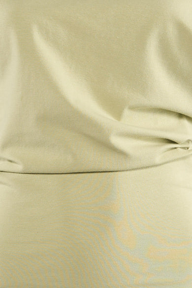 T-shirt vert clair d'Unwind avec une structure en maille fine et des plis doux et ondulés.