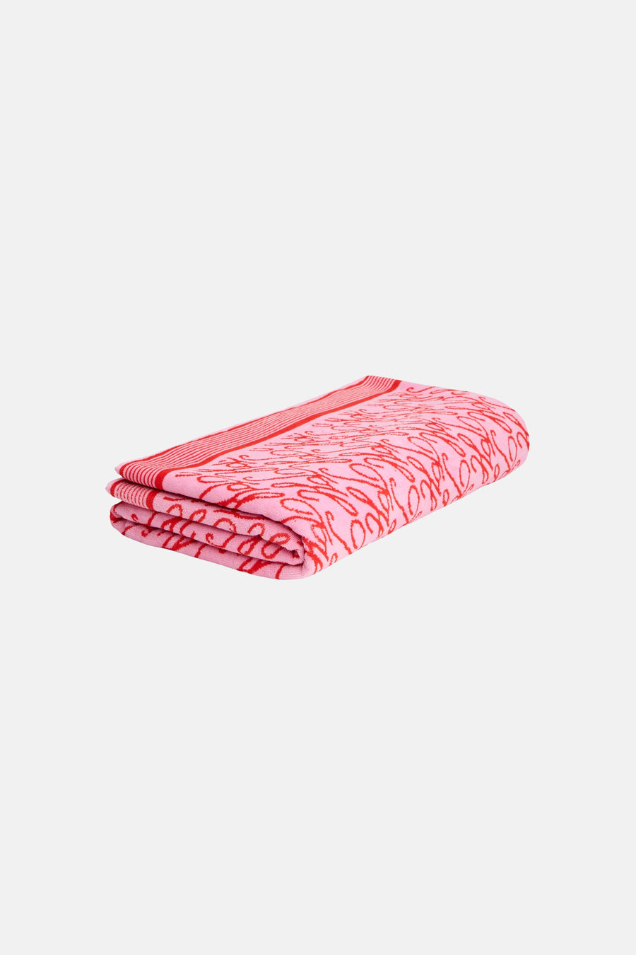 Serviette de plage rose de TOMMY JEANS, pliée avec motif ondulé rouge et rayures.