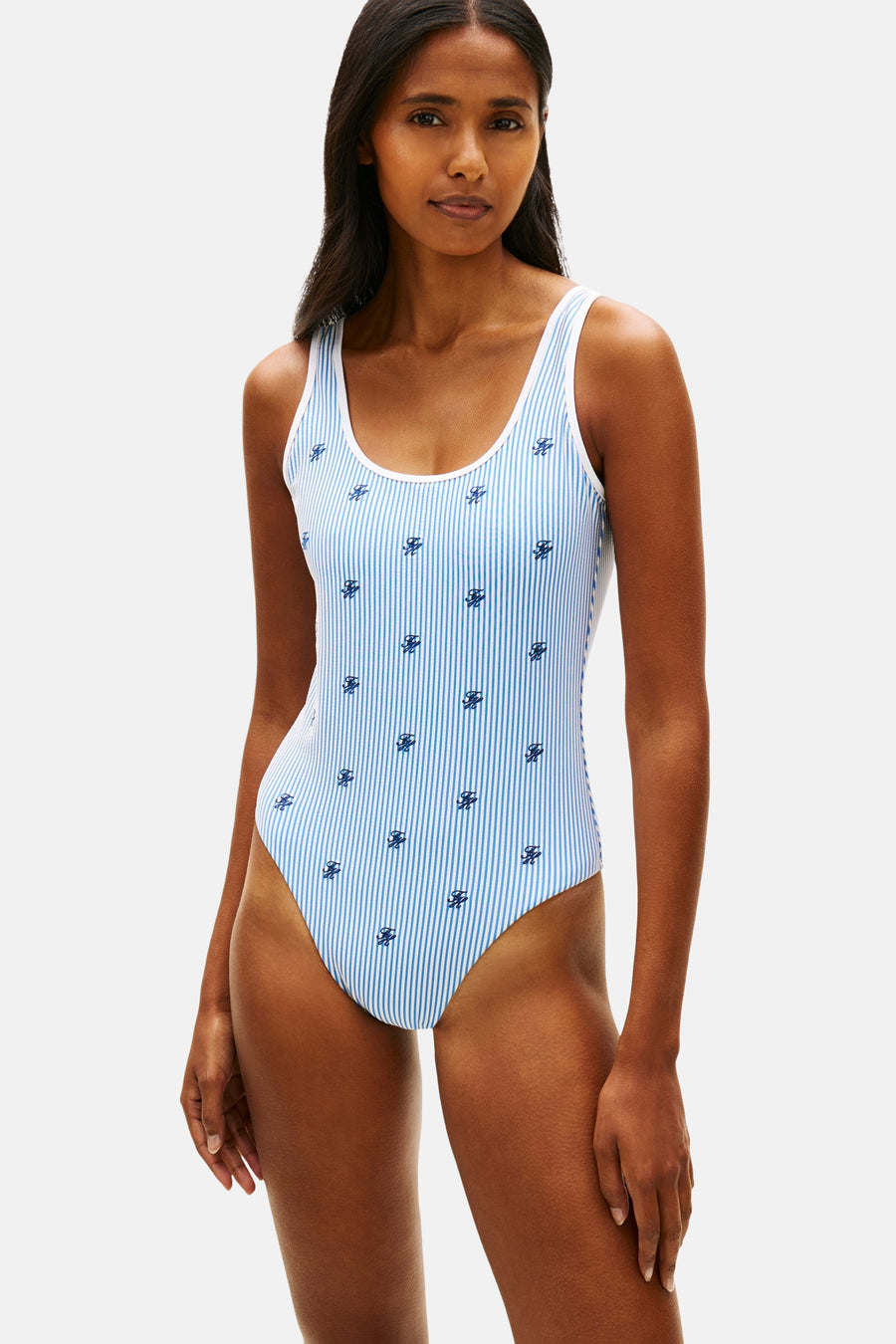 Maillot de bain rayé bleu et blanc de TOMMY JEANS avec des rayures verticales et de petits symboles bleu foncé.