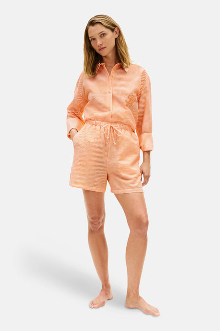 Oranje overhemd van TOMMY JEANS, gestreept met seersucker textuur en geborduurd logo op de borst, gedragen met bijpassende short.