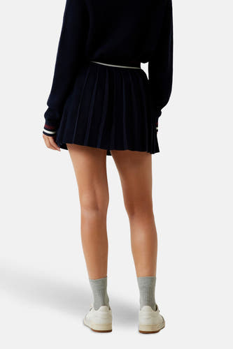 Jupe courte bleue de Guess, avec plis et ceinture rayée.