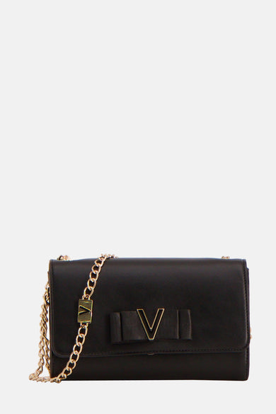 Sac à dos noir de VALENTINO BAGS, avec des détails dorés et porté avec un short blanc.