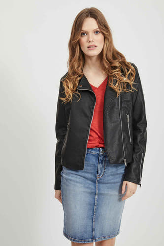 Manteau noir en imitation de fourrure de VILA, avec fermeture éclair, porté sur une chemise rouge et une jupe en denim.