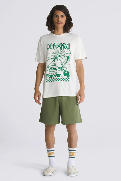 T-shirt écru de VANS "OFF THE WALL" avec imprimé de fleurs vertes, associé à des shorts verts et des baskets crème.