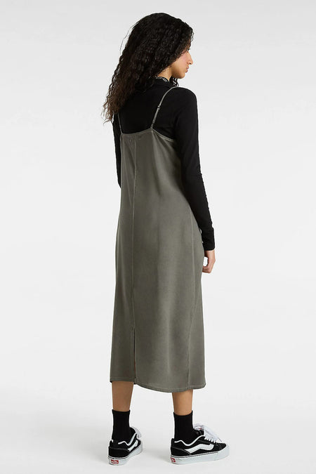 Robe sans manches noire de VANS "OFF THE WALL", portée sur une chemise à longues manches noire et des chaussettes noires avec des baskets.
